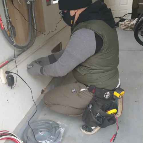 Electrician performing outlet wiring in a Country Club Estates garage